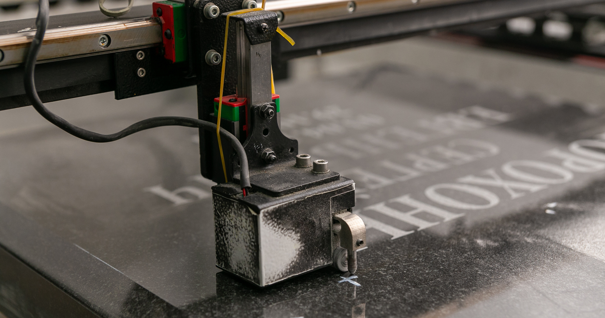 Image of a stone engraving machine placing words on a granite slab